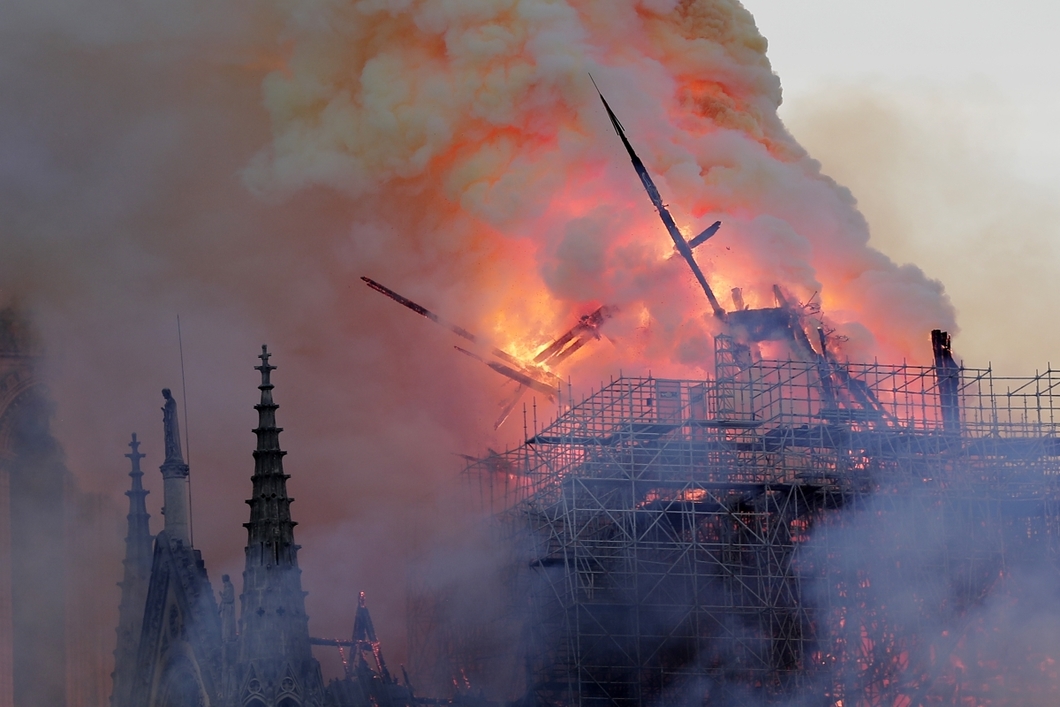 epa07508763 The spire collapses while flames are burning the roof of the Notre-Dame Cathedral in Paris, France, 15 April 2019. A fire started in the late afternoon in one of the most visited monuments of the French capital. EPA-EFE/IAN LANGSDON